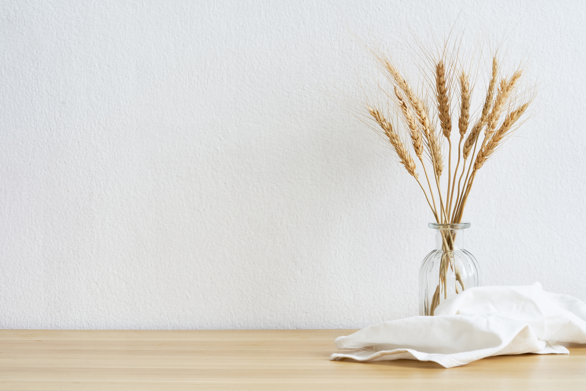 Blank mockup on a white wall with barley wheat on the glasses vase. View of modern style interior with artwork mock up on wall. Home minimalism background                                           